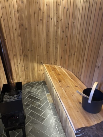 Curved cedar bench above a slate herringbone floor